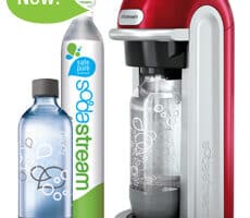 A red and silver SodaStream machine with a clear carbonating bottle inserted, next to a CO2 cylinder labelled "SodaStream" and another empty clear bottle. A green bubble with "New!" appears above the CO2 cylinder.