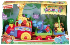 A colourful Fisher-Price toy train set called “Amazing Animals” is in its box. The train has three carriages, each carrying a cheerful animal: a giraffe, an elephant, and a lion with a monkey. The packaging is bright and decorated with jungle artwork.