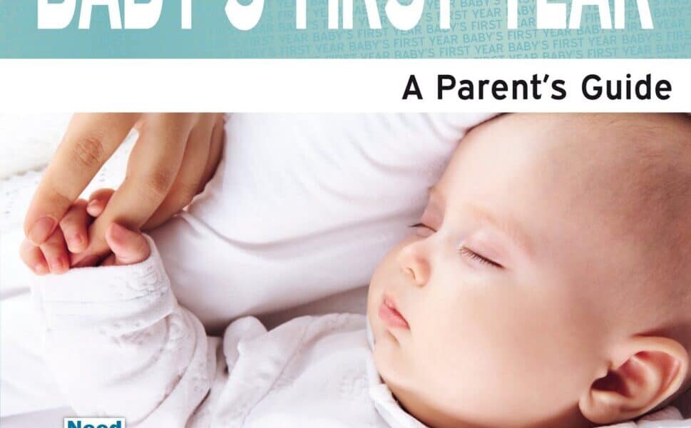 A sleeping baby in a white babygrow lies on a bed, gently holding an adult’s finger. The cover reads “BABY'S FIRST YEAR: A Parent’s Guide” and credits Shanta Everington as the author. The design is soft, with blue and white tones.
