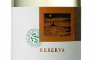 A clear glass bottle of Isla Negra Reserva Sauvignon Blanc wine with a copper screw cap. The label is white with gold and green accents, displaying the name "Isla Negra" and showing it is a Chilean white wine.