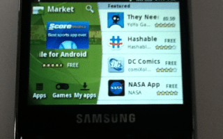 A Samsung mobile phone with a physical QWERTY keyboard displays the Android Market app store. The featured apps include "They Need To Be Fed," "DC Comics," and "NASA App." The time on the phone is 3:47 pm.