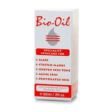 A white box of Bio-Oil with red text. The label lists uses: scars, stretch marks, uneven skin tone, ageing skin, and dehydrated skin. The front also displays the Bio-Oil logo, a striped oil drop graphic, and the product size: 60ml / 2 fl. oz.