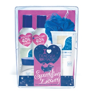 A gift set containing Dead Sea Spa Magik products, including bottles, a tube, and a blue bath puff. The packaging is pink and blue, with labels saying "SPA TIME! 40% EXTRA" and "I ♥ DEAD SEA SPA MAGIK Sparkling Luxury.