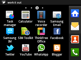A smartphone home screen displays app icons in a grid, including Task manager, Calculator, Voice recorder, Samsung Email, Samsung IM, SIM Toolkit, ThinkFree Office, Facebook, Twitter, YouTube, WhatsApp and Blogger. Notification icons are on the right.
