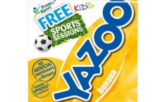 A four-pack of Yazoo banana milk drink in yellow packaging. The label features a large blue Yazoo logo, a football, “FREE KIDS SPORTS SESSIONS,” and notes about no artificial sweeteners or flavours and school approval.