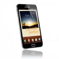 A black Samsung smartphone is displayed at a slight angle. The screen shows a sunset image with silhouettes of two people and white drawn lines above them. Several colourful app icons are visible at the bottom of the screen.