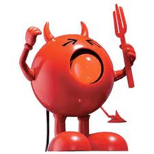 A round, red cartoon figure with small devil horns, a pointy tail, and angry eyes stands with one arm raised in a fist and the other holding a red trident. The figure has a large open mouth as if shouting, and stands on two legs.