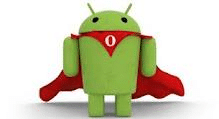A green Android robot stands upright wearing a red superhero cape and a red collar with a white "O" on its chest. The background is plain white, highlighting the robot’s playful, heroic appearance.