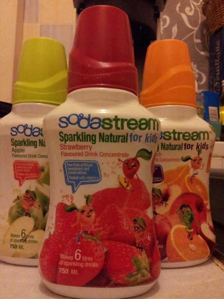 A group of bottles with images of fruit on them.