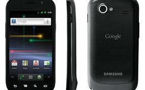 A black Samsung mobile phone is shown from the front, side, and back. The front displays the home screen with Google search and app icons. The back features the Google and Samsung logos, a camera, and a speaker. The phone has rounded edges.