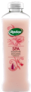 A tall, clear plastic bottle of Radox Spa Soothe Bath Soak with a silver cap. The bottle contains a pink liquid and features pink floral graphic designs and green Radox branding on the label.