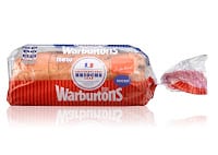 A loaf of Warburtons bread in a red, blue, and white plastic bag, showing the Warburtons logo and labelled as “Medium Sliced.” The bread is partially visible through the clear packaging, set against a white background.