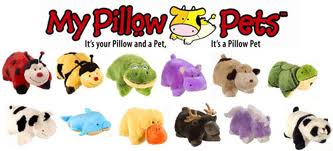 Assorted plush Pillow Pets shaped like various animals, including a ladybird, bumblebee, turtle, purple hippo, cow, dolphin, yellow duck, moose and dog. Above them is the Pillow Pets logo with a cartoon cow and slogan.