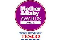 A circular purple logo with "Mother & Baby AWARDS 2011/12" in white text. Below the circle, blue text reads, "PROUDLY SUPPORTED BY TESCO," with the red and blue Tesco logo underneath. The background is white.