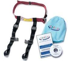 A child aeroplane safety harness with black straps and a red belt is displayed next to a light blue drawstring bag labelled "CARES." Also shown are an instruction manual and a DVD, both branded with the CARES logo.