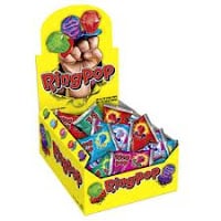 A yellow display box labelled "Ring Pop" holds individually wrapped, colourful Ring Pop lollipops. The box features images of the ring-shaped sweets in various colours and flavours, with several wrappers visible in red, blue, and green shades.