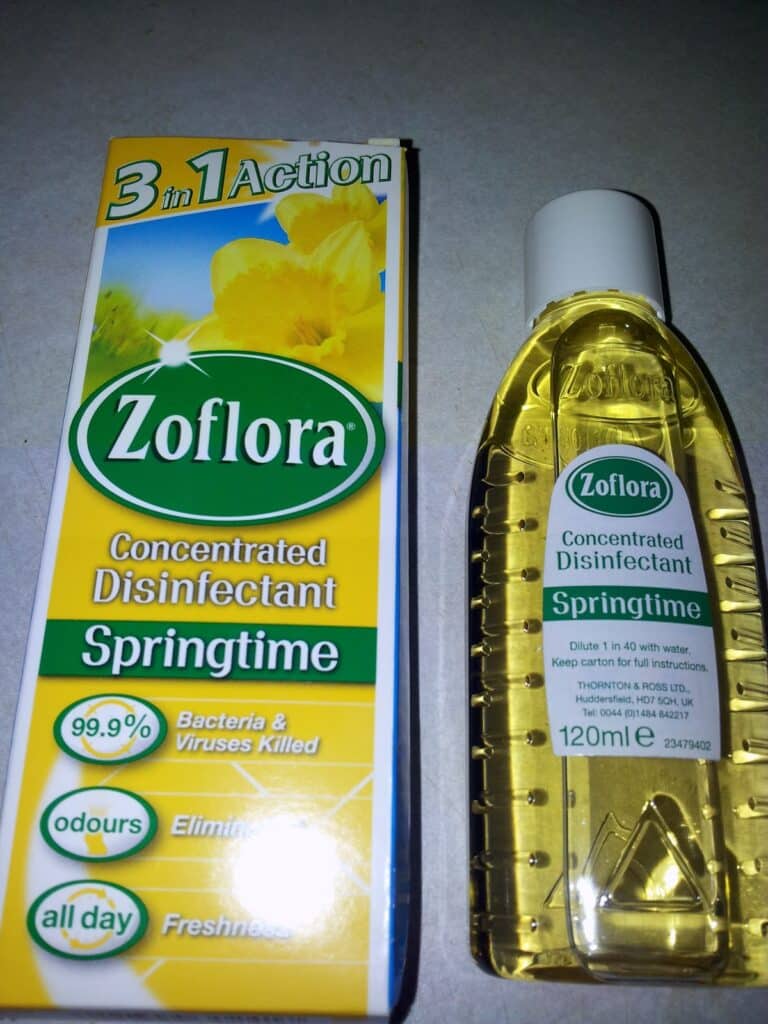 A box and bottle of Zoflora Springtime concentrated disinfectant are shown. The box is yellow, white, and green, highlighting “3 in 1 Action” and claims such as “99.9% bacteria & viruses killed.” The bottle contains 120ml of yellow liquid.
