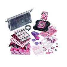 A clear zippered pouch and various pink, purple, and black craft supplies, including patterned papers, stickers, a hole punch, a round cutting tool, string, card cut-outs, and embellishments, arranged neatly on a white surface.