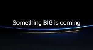 White text on a dark background reads, "Something BIG is coming." A faint blue curve and a shadowy outline of a thin, curved object appear below the text, creating a sense of anticipation and mystery for an upcoming announcement or product.