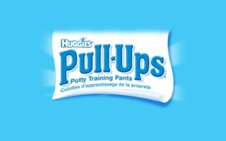 The image shows the Huggies Pull-Ups logo on a bright blue background. Below the Pull-Ups name, it says “Potty Training Pants” and the French translation “Culottes d’apprentissage de la propreté.” The design is clean and simple.