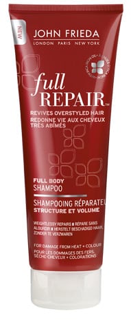 A red tube of John Frieda Full Repair Full Body Shampoo standing upright. The label highlights its purpose to revive overstyled, damaged hair and restore structure and volume. Text is in both English and French, with white and gold accents.
