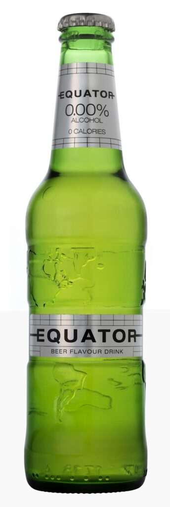 A green glass bottle of Equator beer flavour drink with a silver label. The label states “0.00% alcohol, 0 calories” and “beer flavour drink.” The bottle is unopened, with a silver cap and embossed map details on the glass.