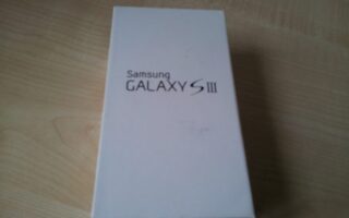 A rectangular white box with "Samsung GALAXY S III" printed in black text on the lid is placed on a light wooden surface. The box is closed and positioned slightly off-centre in the image.