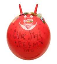 A bright red space hopper with two handles at the top, decorated with sweets and a white smiling face. Handwritten text on the front reads “Chloe Sims REEM” in black marker. The brand logo is visible above the face.