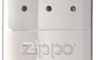 A shiny, metallic Zippo hand warmer with a smooth, reflective surface. The top half features eight small holes arranged in two rows, and the lower half displays the embossed "ZIPPO" logo. The design is sleek and minimalistic.