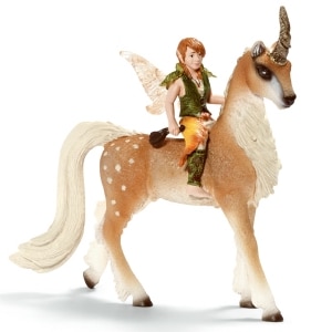 A small fairy figure with orange-brown hair, green wings, and green and orange clothing sits on the back of a tan, white-maned unicorn with a long tail, spotted flank, and brown-tipped horn, facing right. Both are stylised fantasy figurines.