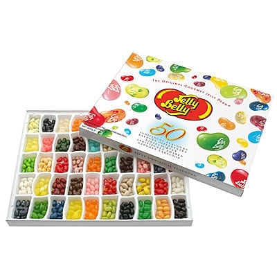 A rectangular Jelly Belly gift box, open to show 50 compartments filled with colourful assorted jelly beans. The lid, decorated with images of jelly beans and the Jelly Belly logo, rests behind the box, displaying the “50 Flavours” collection.