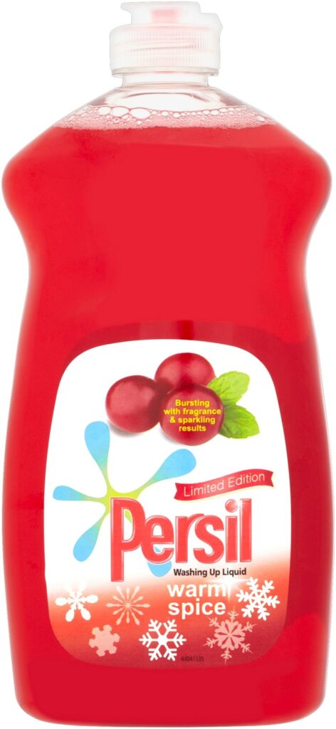 A red bottle of Persil washing-up liquid, labelled "Limited Edition" and "warm spice," featuring images of cranberries, mint leaves, and white snowflakes on the label, with a white flip-top cap.