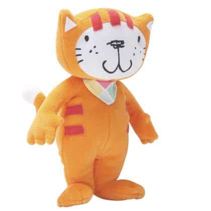 A soft toy shaped like an orange cat stands upright. It has a big white face with a black nose and mouth, black whiskers, round eyes, pink stripes on its head and body, a white-tipped tail, and small white-triangle ears.