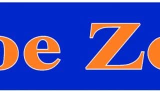 A rectangular blue sign with the words "Shoe Zone" in large, bold orange letters with a slight white outline, centred on the sign. The text uses a serif font and stands out clearly against the solid blue background.