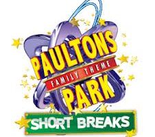 Colourful logo for Paultons Park Family Theme Park. The text is bold and yellow, with “FAMILY THEME” in red. Blue and purple swirls and yellow stars surround the logo. A green sign at the bottom reads “SHORT BREAKS” in white letters.