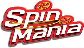 The image shows the "Spin Mania" logo with bold, white and red 3D letters. Yellow swooshes circle around the words, and two red spinning top graphics with yellow accents appear above the text. The background is white.
