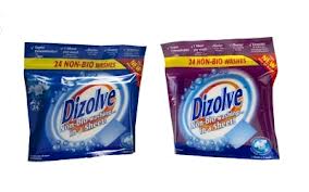 Two packs of Dizolve laundry detergent sheets are shown side by side. The left pack is blue and the right pack is purple. Both display "Dizolve" and "24 Non-Bio Washes" on the packaging, with the image of a detergent sheet and bubbles.