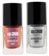 Two bottles of Eye Candy London Cracklin' Up nail varnish are shown. One bottle contains a shimmery pink-orange varnish, and the other contains a shiny silver varnish. Both have black caps and clear glass bases with printed white labels.