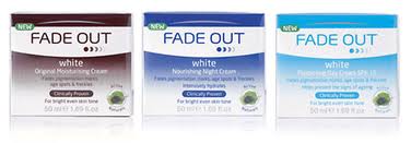 Three boxes of Fade Out brand white moisturising creams are displayed side by side. Each box has a different accent colour: maroon, blue, and light blue. The boxes feature product details and a "Clinically Proven" badge on the front.