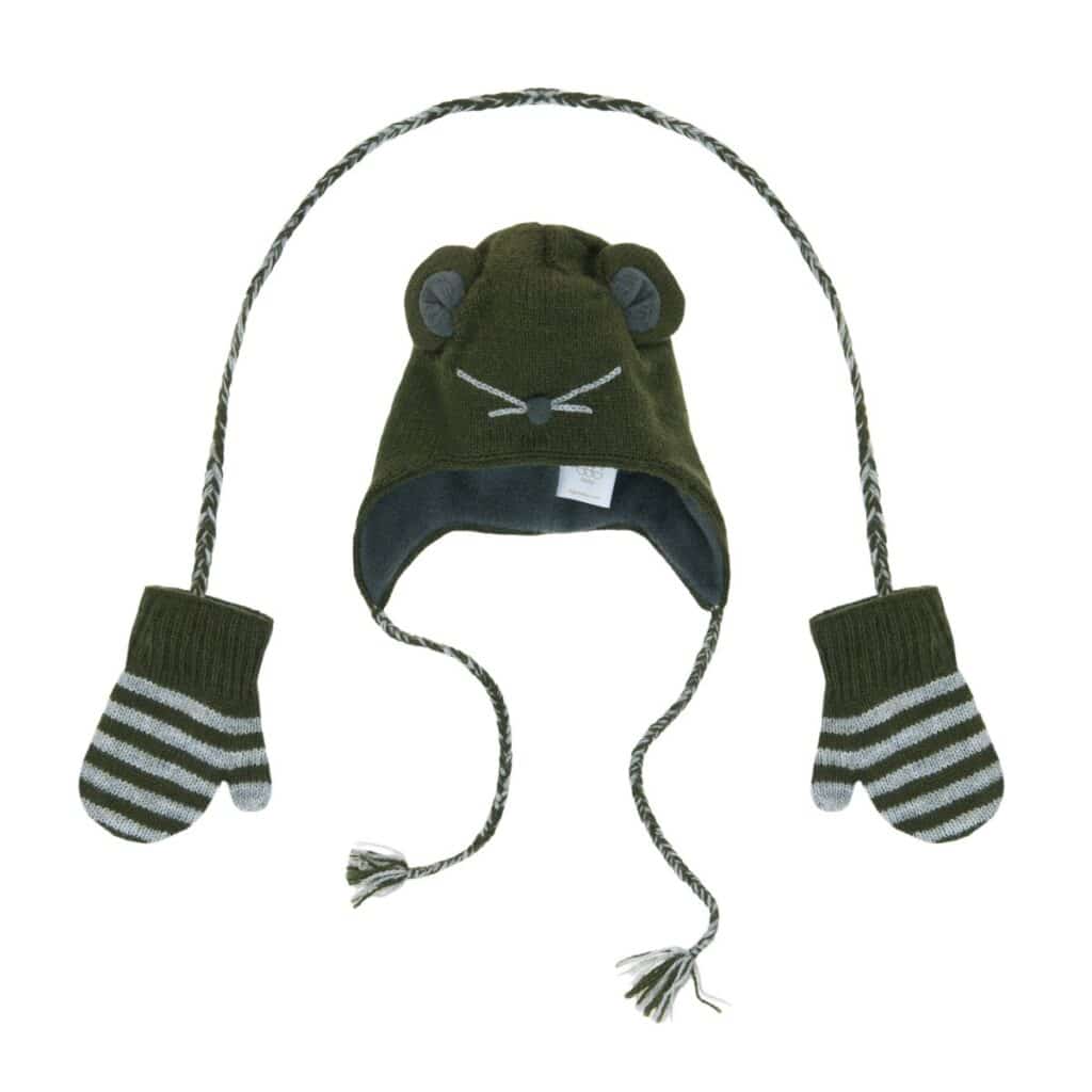 A green knitted winter hat shaped like an animal face with small round ears, embroidered whiskers, and two long plaited ties ending in tassels. Each tie is attached to a matching green mitten with grey and white stripes near the cuffs.