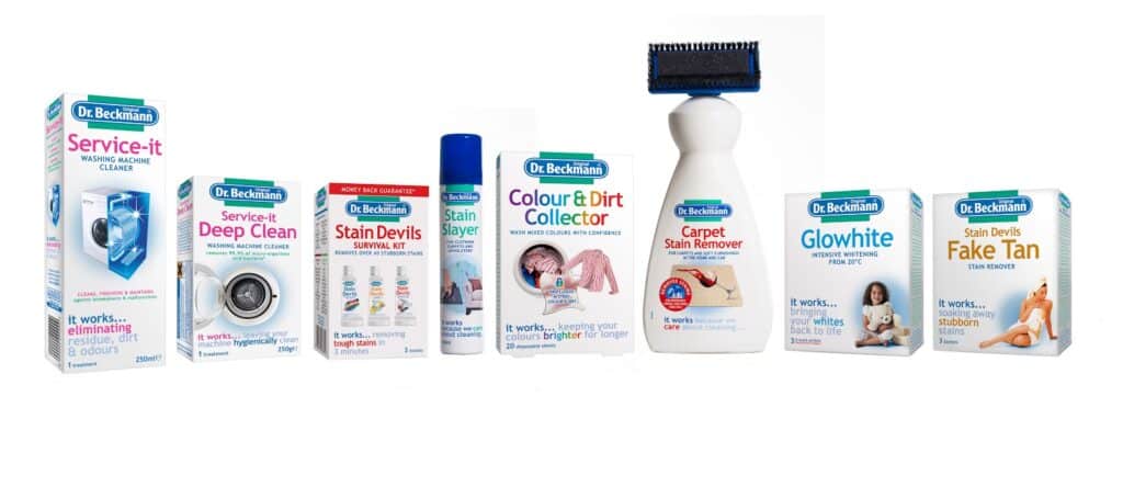 A line-up of eight Dr Beckmann cleaning products, including washing machine cleaner, stain removers, a spray, Colour & Dirt Collector sheets, carpet stain remover with a brush, and laundry additives, all in white packaging with colourful labels on a white background.