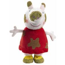 A stuffed toy of Peppa Pig is shown standing with arms outstretched. She is wearing a red dress with brown mud stains and yellow shoes. Peppa has a smiling face with pink cheeks and brown mud spots on her head and snout.