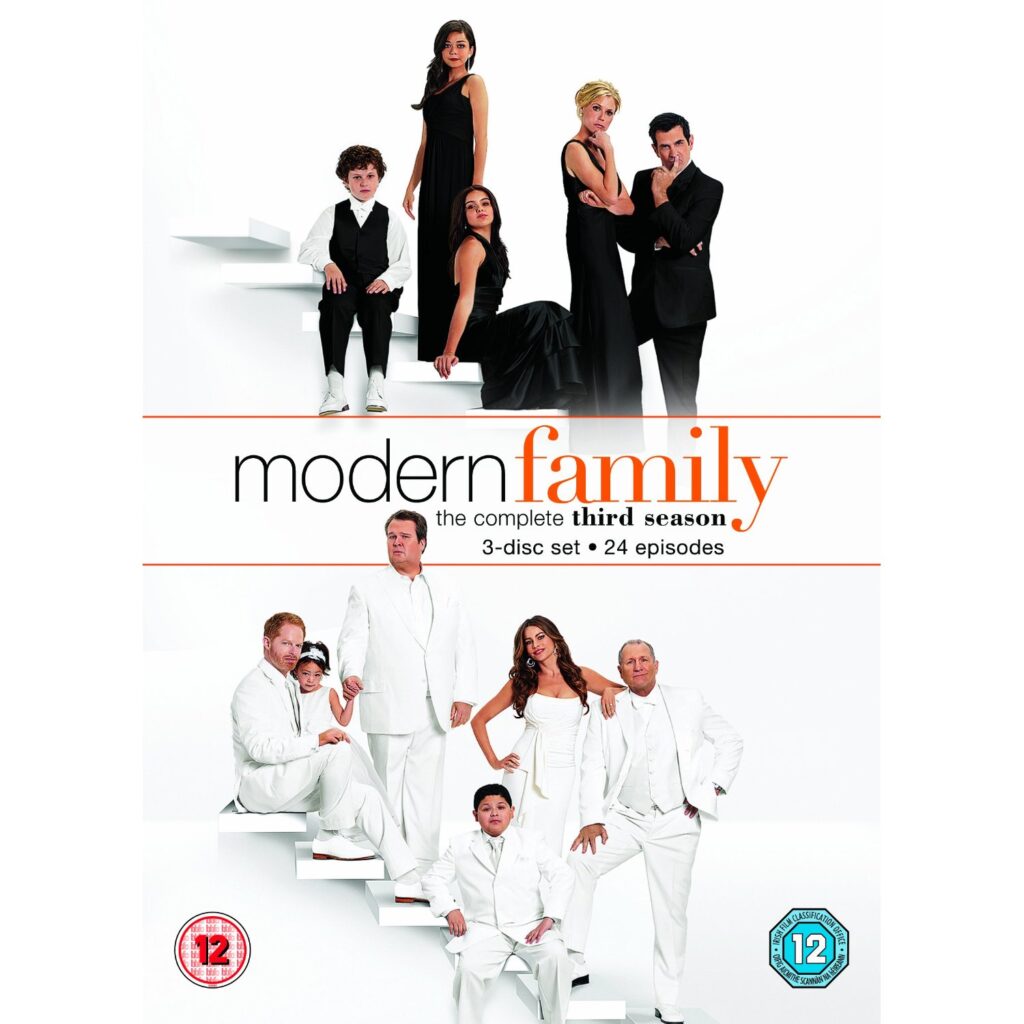 The “Modern Family” series 3 DVD cover shows nine main characters. Top group wears black, bottom group wears white. They pose on white stairs against a white background. Title text and episode info are centred in the middle. Age rating logos appear at the bottom corners.