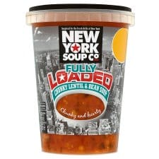 A plastic tub of New York Soup Co. Fully Loaded Chunky Lentil & Bean Soup with a black lid. The label features a city skyline and bold, colourful text. The soup inside is visible through the transparent lower half of the container.