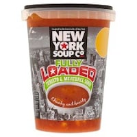 A plastic tub of New York Soup Co. Fully Loaded Tomato & Meatball Soup with a black-and-white NYC skyline background, bold white and red logo, and visible chunky red soup inside. The label says "chunky and hearty." The tub has a clear lid.