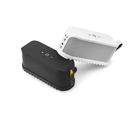 Two portable Bluetooth speakers are shown; one is black with visible control buttons on top, and the other is white with a mesh front and buttons on its angled top. Both have rugged edges and are positioned diagonally on a plain white background.