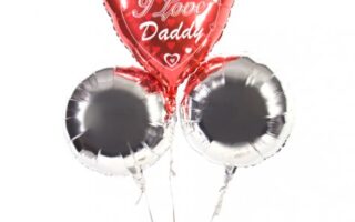 Three helium balloons: one red heart-shaped balloon with white hearts and the words "I Love Daddy" in cursive, and two round silver balloons. All are attached to white strings against a plain white background.