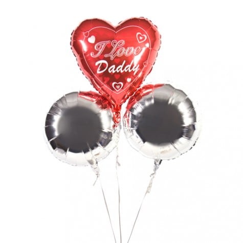 Three helium balloons: one red heart-shaped balloon with white hearts and the words "I Love Daddy" in cursive, and two round silver balloons. All are attached to white strings against a plain white background.