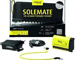 Retail packaging for the Jabra Solemate portable speaker, featuring the black speaker, yellow accents, a USB charging cable, a 3.5mm audio cable, a carrying bag, and product branding with the tagline “The Ultimate Portable Speaker”.