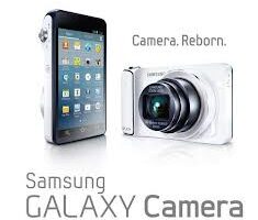 A Samsung Galaxy Camera is shown from two angles: front with an extended lens, and back displaying a touchscreen with app icons. The text reads “Camera. Reborn.” and “Samsung GALAXY Camera” on a white background.